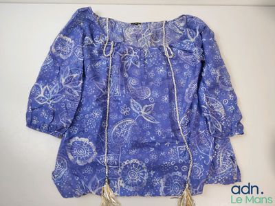 a blue blouse with a gold chain on it