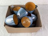 five cups in a box on the floor