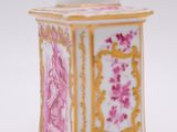 a pink and gold jar with a picture on it