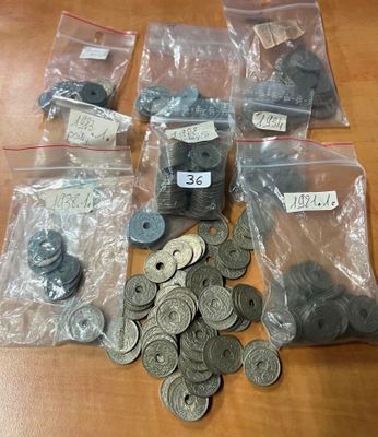 de nombreuses pièces de monnaie de toutes sortes, rangées dans des sachets posés sur une table