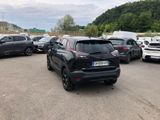 many cars parked in a parking lot with mountains in the background