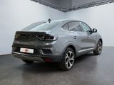 the rear end of a silver car in a white room