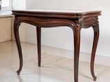 une table en bois avec un plateau en marbre dans une pièce