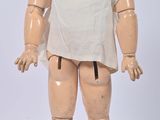 a doll that is standing on a white surface