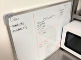 a white board on the wall next to a microwave
