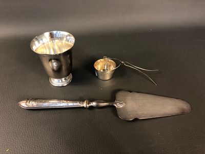 une cuillère en argent et une tasse en argent posées sur une table