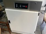 a white dishwasher sitting in a kitchen next to a chair