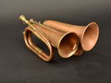an old brass trumpet sitting on top of a black surface