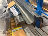 un gros plan sur un rail métallique dans un entrepôt où se trouvent des palettes et des cartons