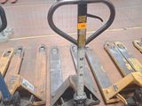 Plusieurs palettes sont empilées les unes sur les autres dans un entrepôt
