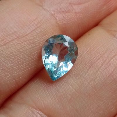 une image représentant une personne tenant des pierres précieuses de topaze bleue