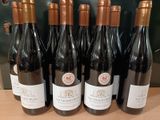 six bouteilles de vin sont alignées sur une table