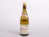une vieille bouteille de vin posée sur une table blanche