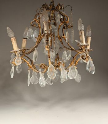 un lustre ancien en laiton orné de pendants en verre transparent suspendu au plafond