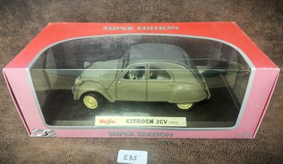 une vieille maquette de voiture dans une boîte rose posée sur une surface marron