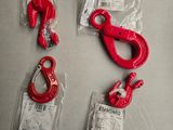 trois crochets rouges et une paire de crochets posés sur une table