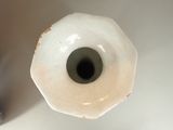 a close up of a white vase with a black hole in it