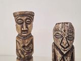 two wooden figurines sitting next to each other on a table