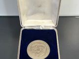 a close up of a silver medal in a case on a table