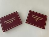 pair of maroon colored business cards with gold lettering on them