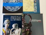 quatre livres posés sur une table sur laquelle se trouve un vase