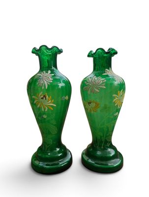 une paire de vases verts ornés de fleurs dorées sur fond blanc
