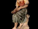 an image of a statue of a woman sitting on a rock