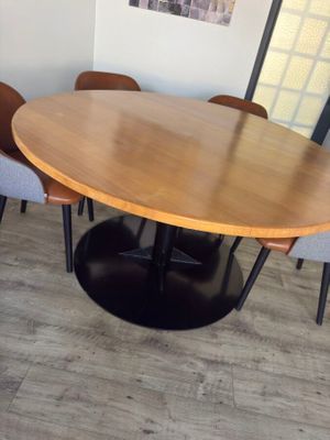 a wooden table with chairs around it in a room