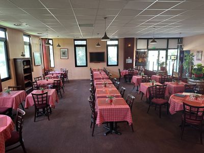 Ce restaurant compte de nombreuses tables et chaises recouvertes de nappes roses.