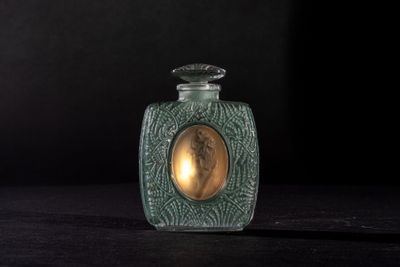 a glass bottle with a picture on it on a table