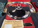 a silver plate with a black lid on a red box