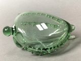 a green glass bowl sitting on top of a table