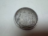 a close up of a silver coin on a white surface