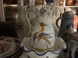 a white vase with a bird on it sitting on a table