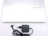 a white laptop with a power cord and a charger