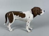 a figurine of a brown and white dog on a gray background