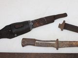 a knife, a knife blade, and a hammer on a table
