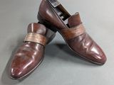 pair of men ' s brown leather shoes on a grey surface