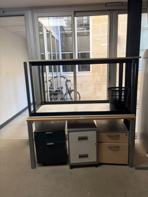 a desk with two drawers and a bike in the background