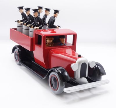 a red toy truck with a bunch of people in it