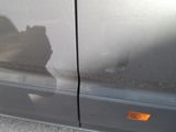 a cat that is sitting on the side of a car
