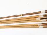 Plusieurs baguettes en bois sont alignées sur une surface blanche