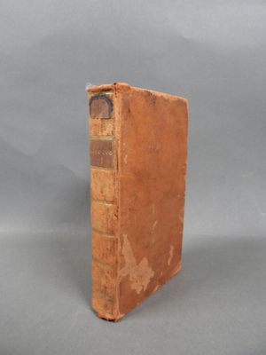 an old book sitting on top of a table with a gray background