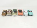 several toy cars are lined up in a row on a white surface