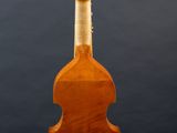 an old violin on a stand against a gray background