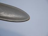 a spoon that has a spoon on it with a blue sky in the background