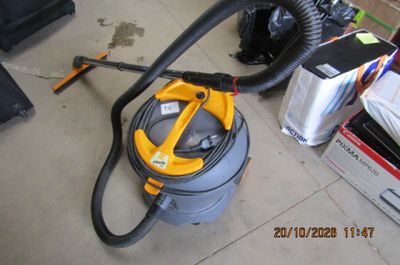 un aspirateur posé sur le sol à côté d'autres objets