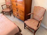 two chairs and a dresser in a room