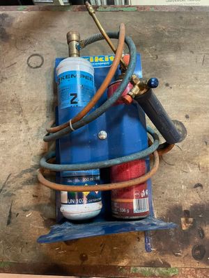 une borne d'incendie bleue à laquelle est raccordé un tuyau