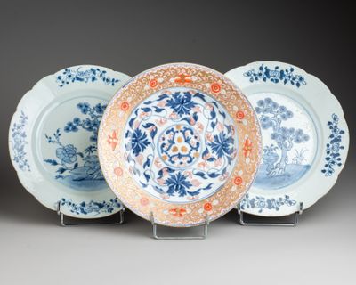 three blue and white plates with floral designs on them sitting on a stand